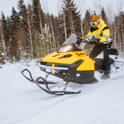 a-man-rides-a-yellow-snowmobile-through-a-winter-f-2026-01-07-06-38-03-utc