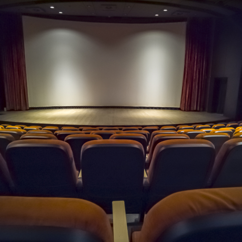 Empty chairs in the stands of the movie theater. Many empty seats for spectators.